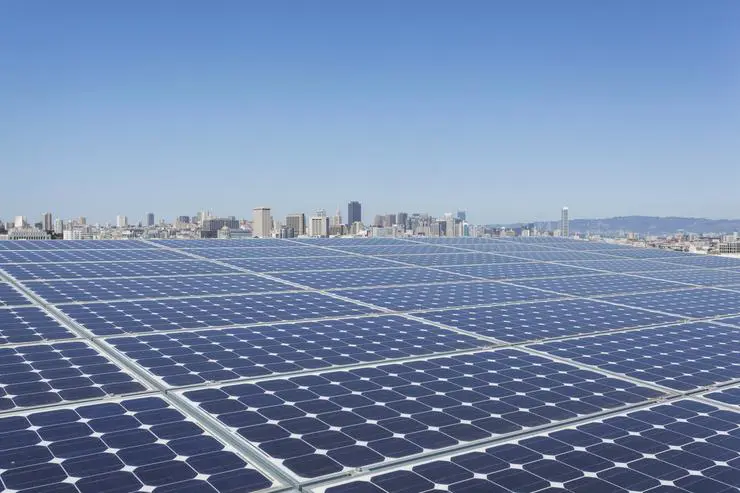 Solar power plant behind a city scape