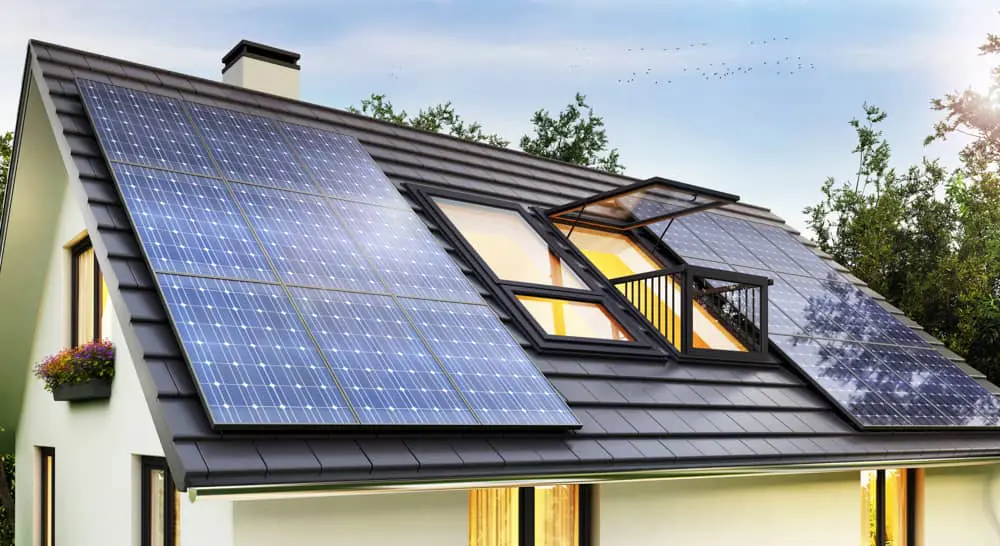Solar panels on a shingled roof on either side of a skylight