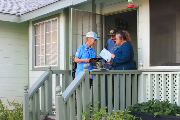 Middle age couple meeting with a solar expert on their front porch